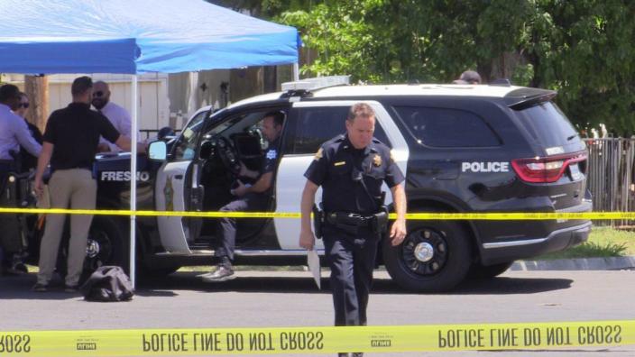 Fresno police officers gather at the shooting scene on Magill Avenue near Blackstone Avenue on Sunday, July 30, 2023 after a teenager was shot by an officer.