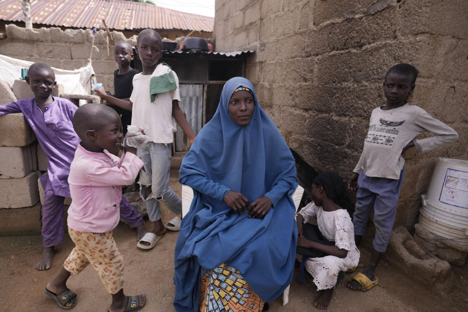 Aisha Aliyu, 36-year-old mother of five, who talked about how her last child "used to be skinny but is growing fatter" because of what they now grow at home is photographed with her children in Kaltungo Poshereng Nigeria, Sunday, June 2, 2024. More than a dozen women gathered this week in Kaltungo's Poshereng village where they are learning at least 200 recipes they can prepare with those local foods which, in the absence of rain, are grown in sand-filled sacks that require small amounts of water. The training session mirrored the struggles of households who are more challenged amid Nigeria's worst cost of living crisis. (AP Photo/Sunday Alamba)