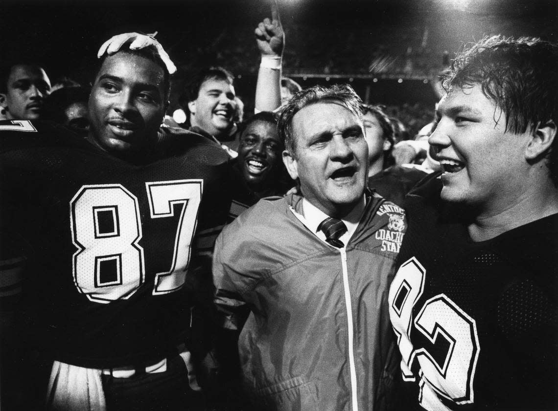 Jerry Claiborne, flanked by co-captains Oliver White (87) and David Thompson (92), celebrates after UK defeated Wisconsin 20-19 in the 1984 Hall of Fame Bowl.