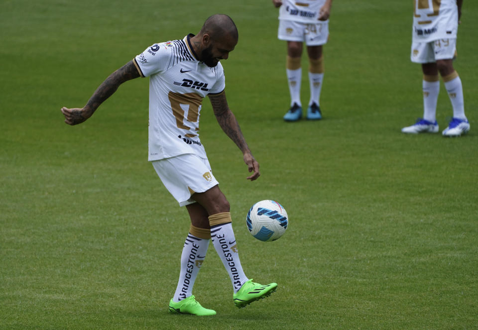 Brazilian Dani Alves juggles the ball during his presentation as a new member of the Pumas UNAM soccer club, on the pitch at the Pumas training facility in Mexico City, Saturday, July 23, 2022. (AP Photo/Marco Ugarte)