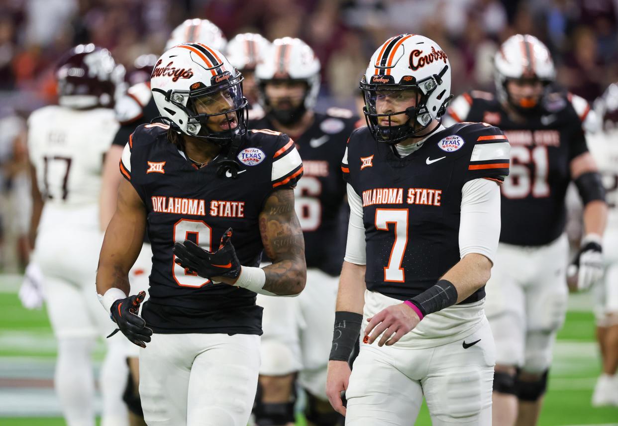 Dec 27, 2023; Houston, TX, USA; Oklahoma State Cowboys running back Ollie Gordon II (0) talks to quarterback Alan Bowman (7) after the Cowboys turned over the ball on downs against the Texas A&M Aggies in the second half at NRG Stadium. Mandatory Credit: Thomas Shea-USA TODAY Sports
