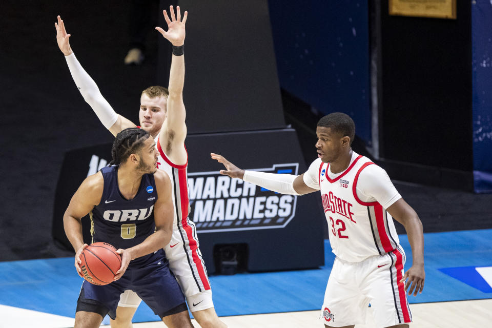 Oral Roberts' Kevin Obanor (0) gets pressure from Ohio State's Justin Ahrens, center, and E.J. Liddell (32) during the first half of a First Round game in the NCAA men's college basketball tournament, Friday, March 19, 2021, at Mackey Arena in West Lafayette, Ind. (AP Photo/Robert Franklin)