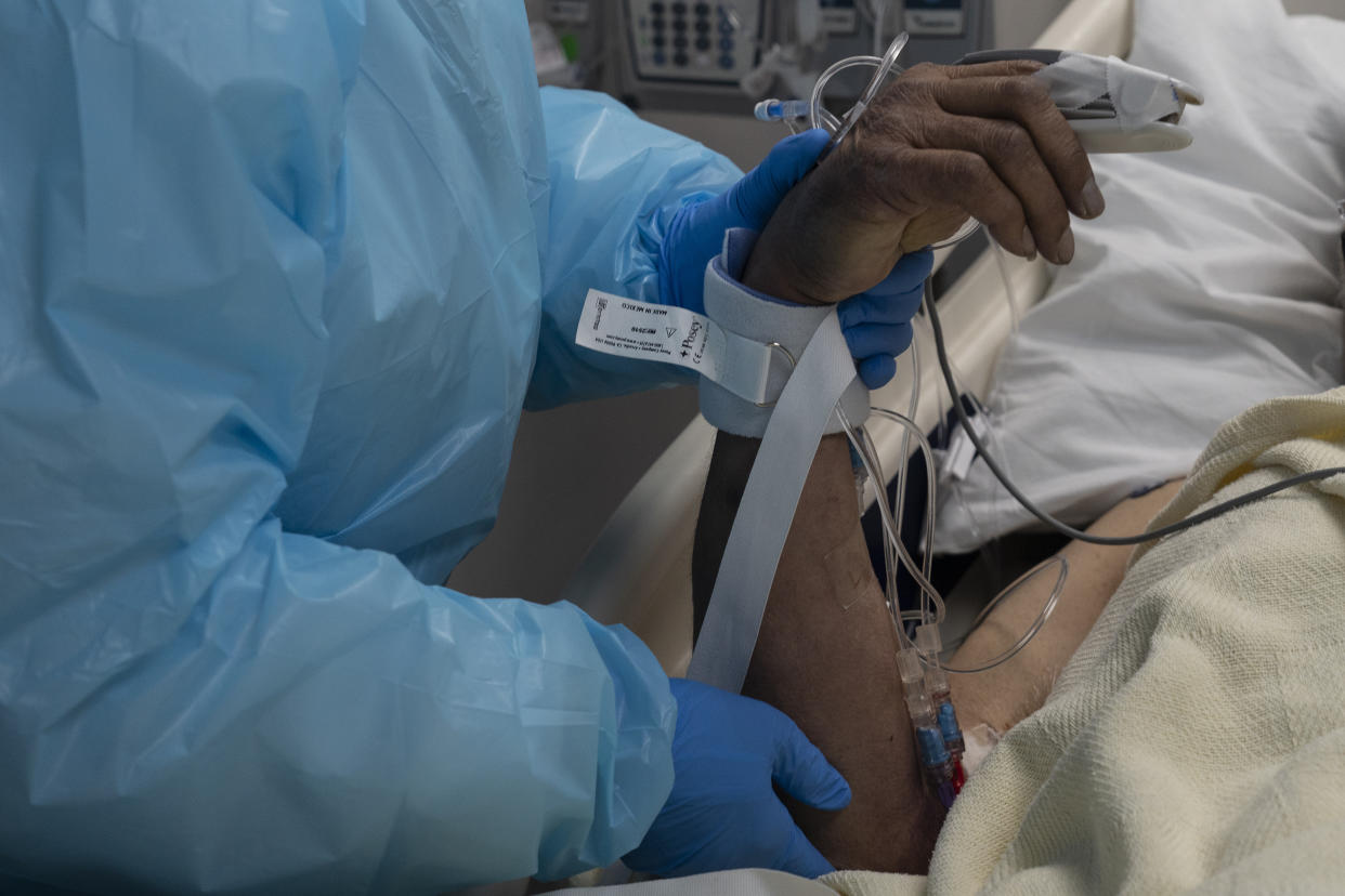 A medical staff member holds a hand of a patient