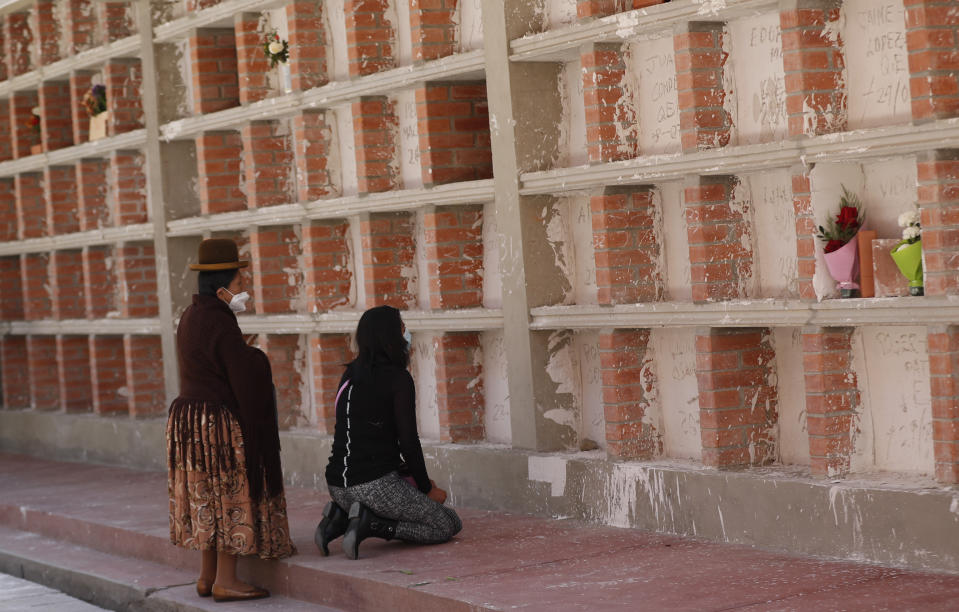 Una mujer reza frente a tumbas de personas que fallecieron por complicaciones de COVID-19 en el Cementerio General de La Paz, Bolivia, el miércoles 23 de septiembre de 2020. (AP Foto/Juan Karita)