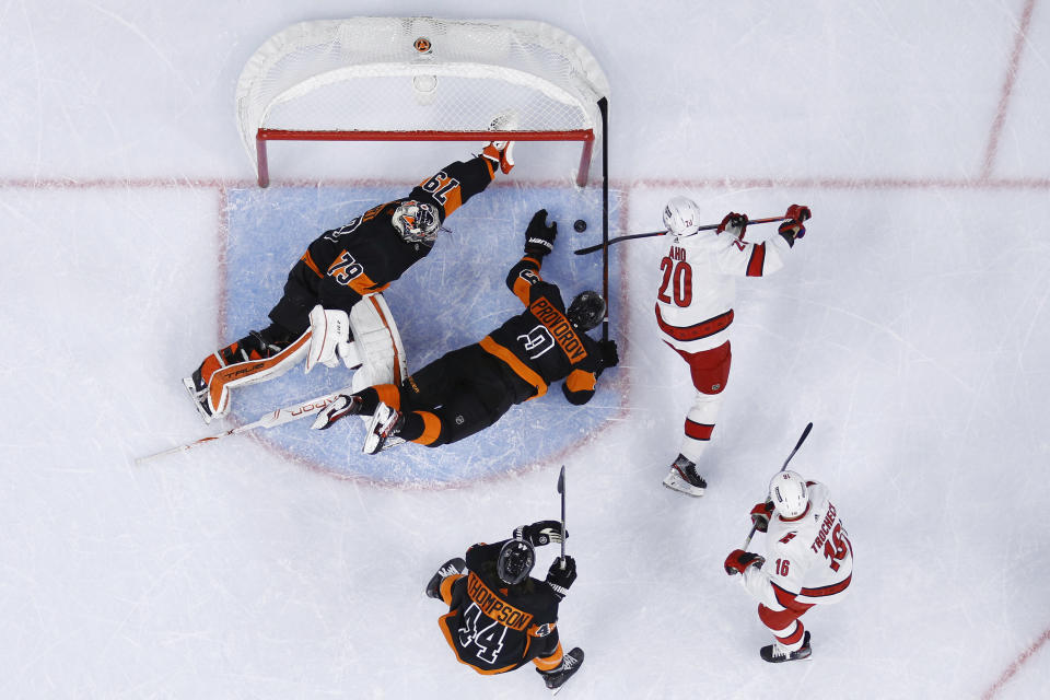 Carolina Hurricanes' Sebastian Aho (20) cannot get a shot past Philadelphia Flyers' Ivan Provorov (9) and Carter Hart (79) during the first period of an NHL hockey game, Friday, Nov. 26, 2021, in Philadelphia. (AP Photo/Matt Slocum)