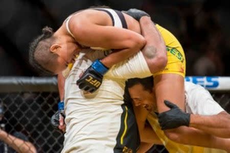 Jul 9, 2016; Las Vegas, NV, USA; Amanda Nunes (blue gloves) reacts after defeating Miesha Tate (red gloves) during UFC 200 at T-Mobile Arena. Nunez won by rear naked choke. Mandatory Credit: Joshua Dahl-USA TODAY Sports