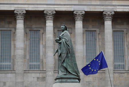 An EU flag is waved next to a statue of Queen Victoria on the first day of the Conservative Party Conference in Birmingham, Britain, September 30, 2018. REUTERS/Darren Staples