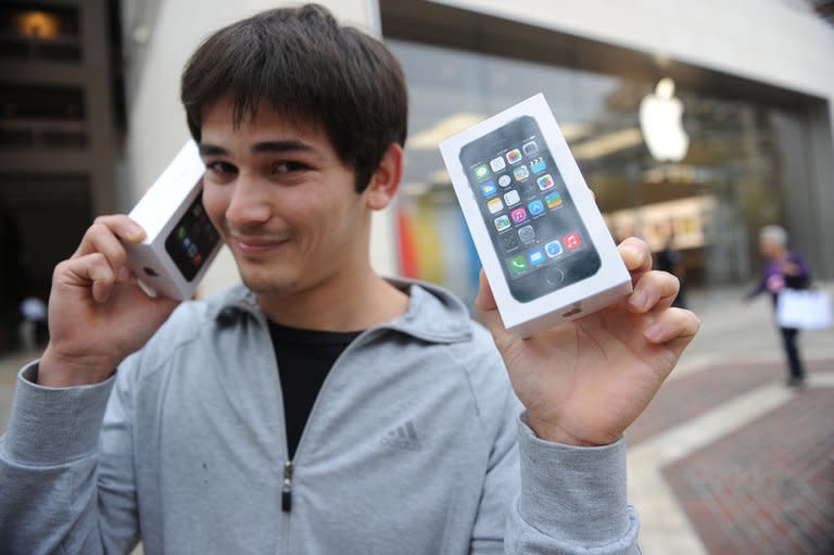 A man poses with his two new Apple iPhone 5S in Glendale, California, September 20, 2013. Apple said it sold a record nine million iPhones in the three days after launching two new versions of the smartphone