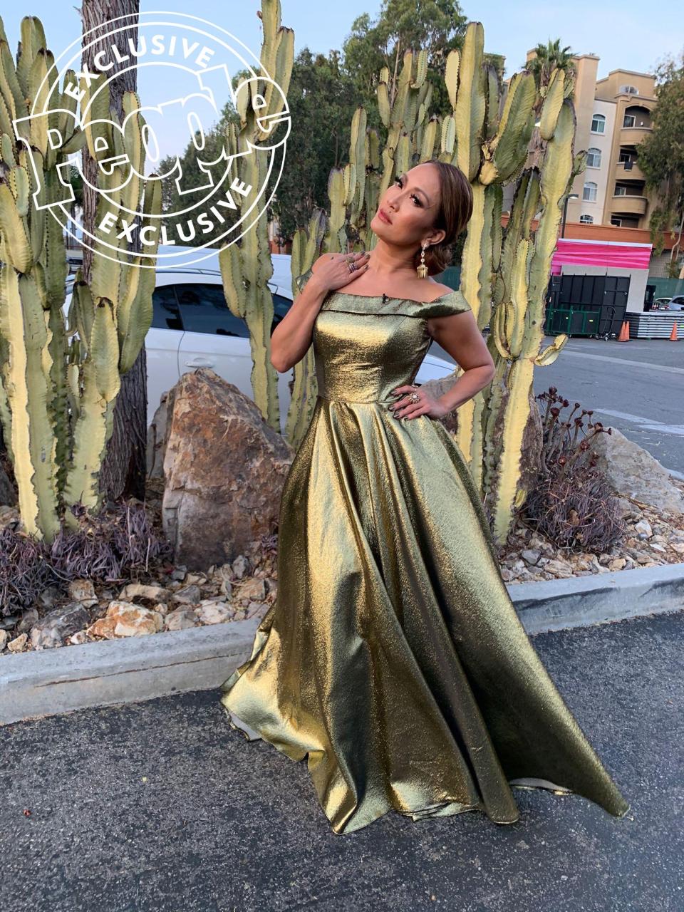 After switching things up with a cocktail dress last week, Carrie Ann went back to her ballgown roots for the Boy Band and Girl Group-themed episode wearing a shimmery off-the-shoulder dress by <a href="https://click.linksynergy.com/deeplink?id=93xLBvPhAeE&mid=1237&murl=https%3A%2F%2Fshop.nordstrom.com%2Fc%2Fwomens-dresses-shop%2Ffilter%2Fmac-duggal%7Ebrand_11958&u1=PEO%2CCarrieAnnInaba%27sDWTSPhotoDiary%3ASeeHowtheJudgeGetsReadyBehindtheScenes%2Channakateflanagan1%2CUnc%2CGal%2C7299401%2C201911%2CI" rel="nofollow noopener" target="_blank" data-ylk="slk:Mac Duggal.;elm:context_link;itc:0;sec:content-canvas" class="link ">Mac Duggal.</a>