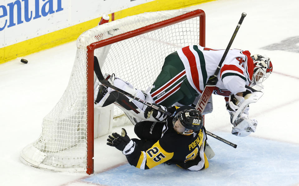 Pittsburgh Penguins center Ryan Poehling (25) collides with New Jersey Devils goaltender Vitek Vanecek (41) during the third period of an NHL hockey game Tuesday, April 4, 2023, in Newark, N.J. The New Jersey Devils won 5-1. (AP Photo/Noah K. Murray)