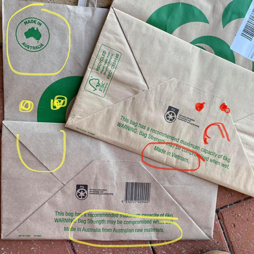 A photo taken by a Woolworths customer showing the new manufacturing country of the paper bag and an old bag that is 