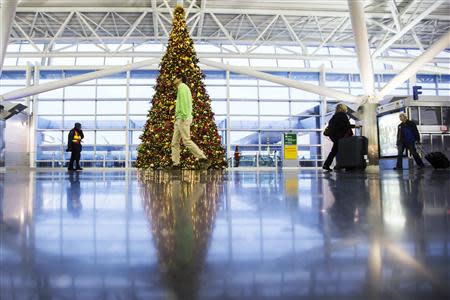 Travelers walk past a large Christmas tree inside of John F. Kennedy International Airport in New York, November 27, 2013. REUTERS/Lucas Jackson