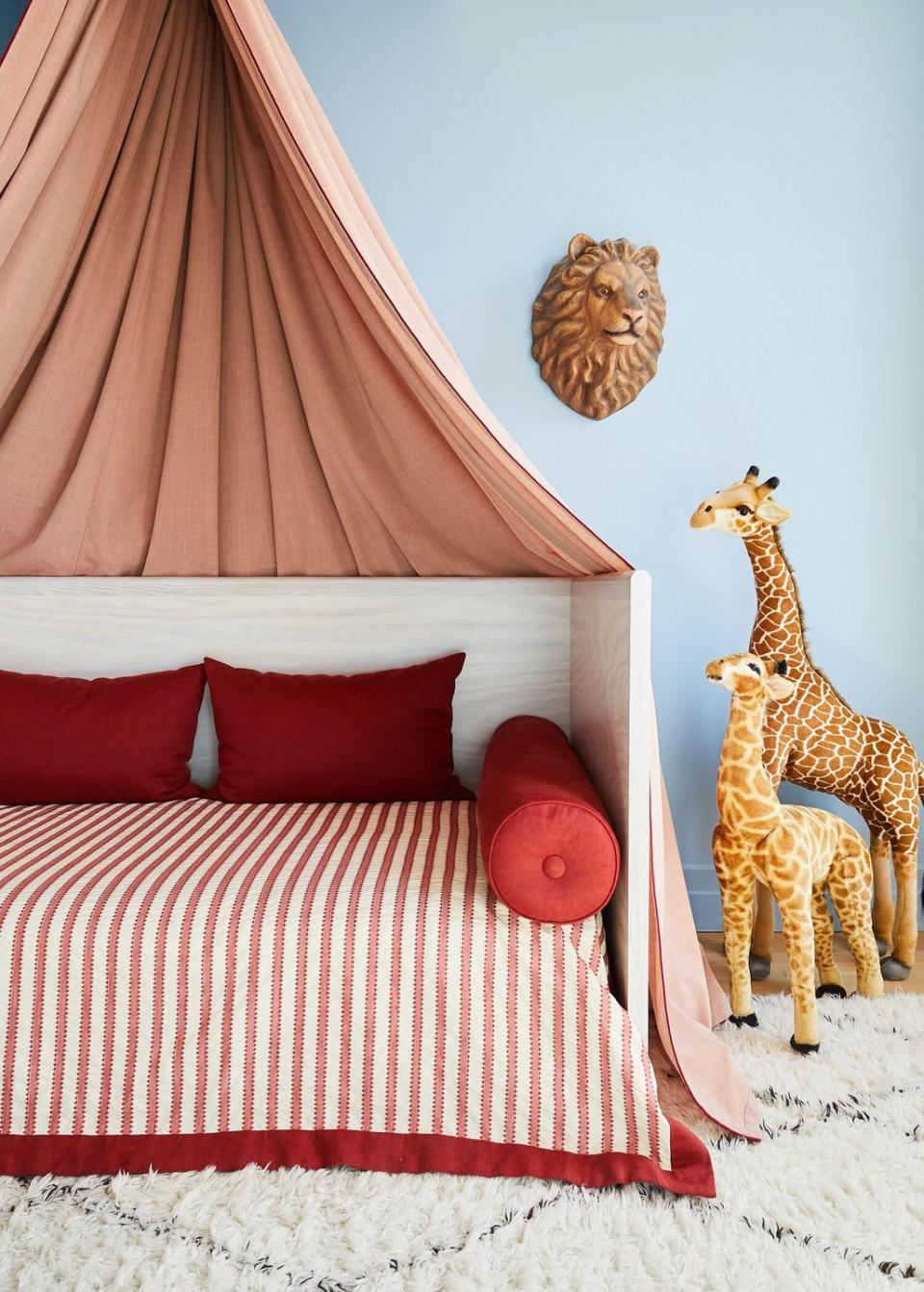 <p>What better place to look for nursery inspiration then a retro circus? Hang a little tent-like canopy over a daybed, opt for red and cream striped textiles, and pile on some throw and bolster pillows. Then pack in the animal motifs. Today, the daybed can be used as a comfy place for late-night feedings, but one day it'll be a big-kid bed—stylish, ageless, multi-purpose furniture is always a good investment.</p>