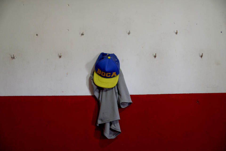 This Sept. 8, 2018 shows Candelaria Cabrera's jersey and Boca Juniors' cap in the Huracan dressing room, in Chabas, Argentina. She was 3 years old when her parents gave her her first ball. They understood that it didn't make sense to insist she play with dolls, even if there were "comments from other moms that they should not give her male toys because it would encourage her to be a lesbian," Candelaria's mother said. (AP Photo/Natacha Pisarenko)