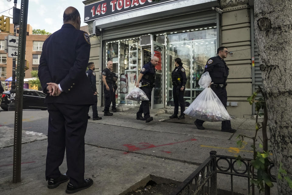 New York City's Sheriff Anthony Miranda, left, watches as members of New York Sheriff's Joint Compliance Task Force (SJCTF) carry bags of confiscated vaping products, during a spot raid of a tobacco shop, Wednesday Sept. 27, 2023, in New York. Communities across the U.S. are confronting a new vaping problem: how to get rid of millions of disposable e-cigarettes that are considered hazardous waste. The devices contain nicotine, lithium and other materials that cannot be reused or recycled. (AP Photo/Bebeto Matthews)