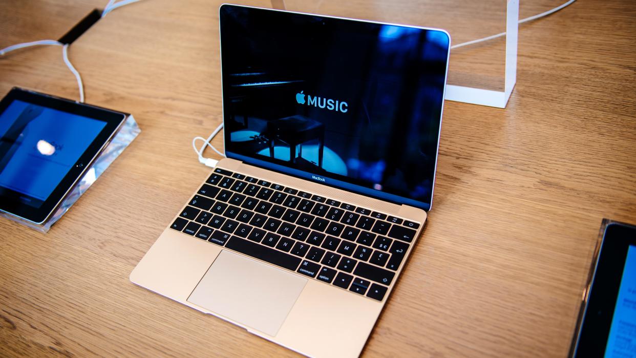  The 2015 MacBook 12-inch in rosegold pictured on a wooden table. 