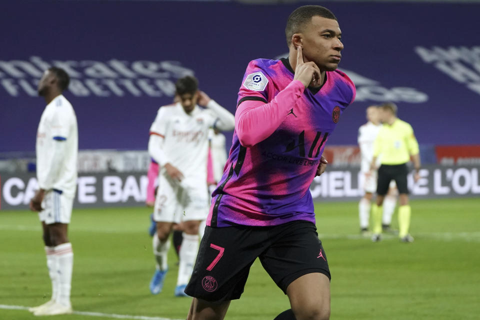 Kylian Mbappé celebra tras anotar un gol para el Paris Saint-Germain en la victoria 4-2 de visita contra Lyon en la liga francesa, el domingo 21 de marzo de 2021. (AP Foto/Laurent Cipriani)