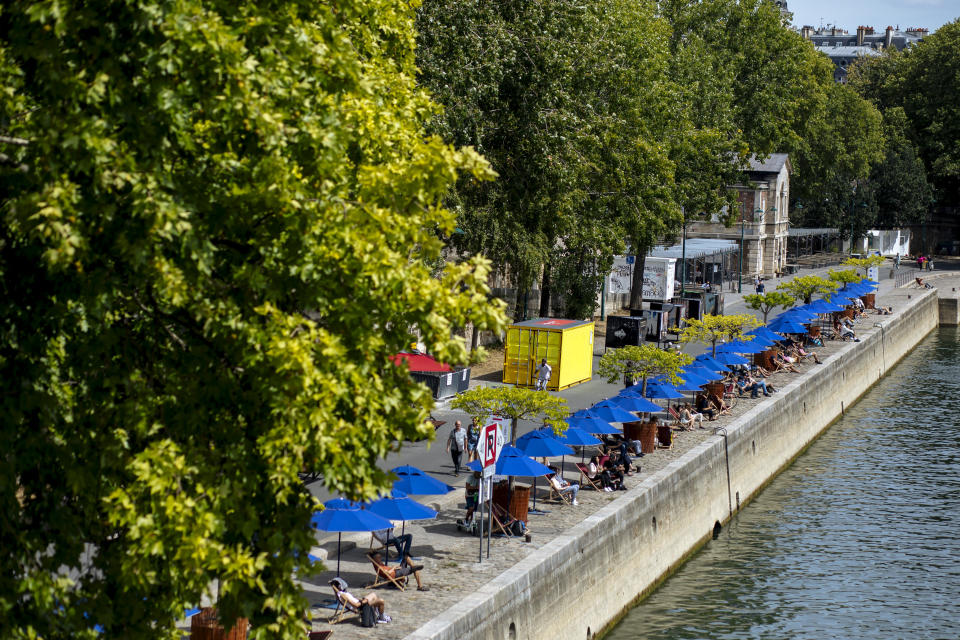 ARCHIVO - En esta imagen del 28 de julio de 2020, gente disfrutando del buen tiempo en sillas junto al río Sena en París.Un brote de coronavirus en una zona turística de Francia se está convirtiendo en un ejemplo de manual de cómo el virus enfrenta generaciones entre sí. En una semana se han descubierto 72 casos, la mayoría en veraneantes y trabajadores de temporada entre 18 y 25 años. (AP Foto/Kamil Zihnioglu, Archivo)