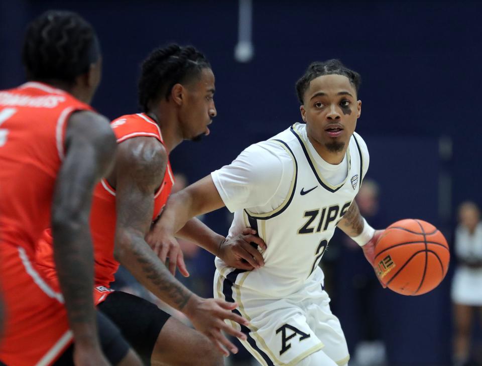 Akron Zips guard Greg Tribble (2) looks past a pair of Bowling Green Falcons defenders during the first half of an NCAA college basketball game, Friday, Jan. 5, 2024, in Akron, Ohio.