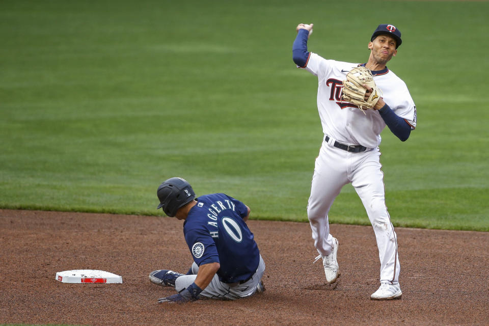 Minnesota Twins shortstop Andrelton Simmons throws to first after forcing out Seattle Mariners' Sam Haggerty, for a double play on a ball hit by J.P. Crawford during the seventh inning of a baseball game Thursday, April 8, 2021, in Minneapolis. The Twins won 10-2. (AP Photo/Bruce Kluckhohn)