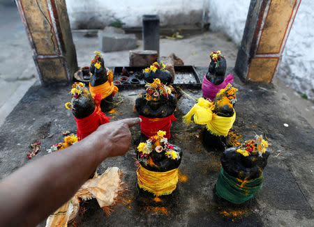 Paramasivan points to the statue of sun god Surya at a temple outside the Kodaikanal Solar Observatory, India, February 5, 2017. REUTERS/Danish Siddiqui