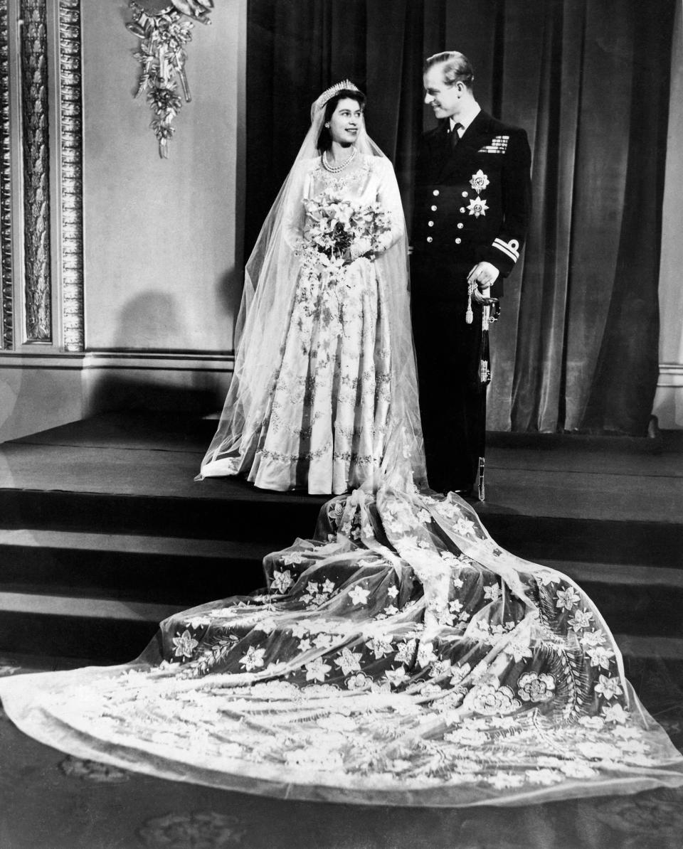 A posed photograph of the young couple in Buckingham Palace, after their wedding, showed the detail of the Queen’s train.