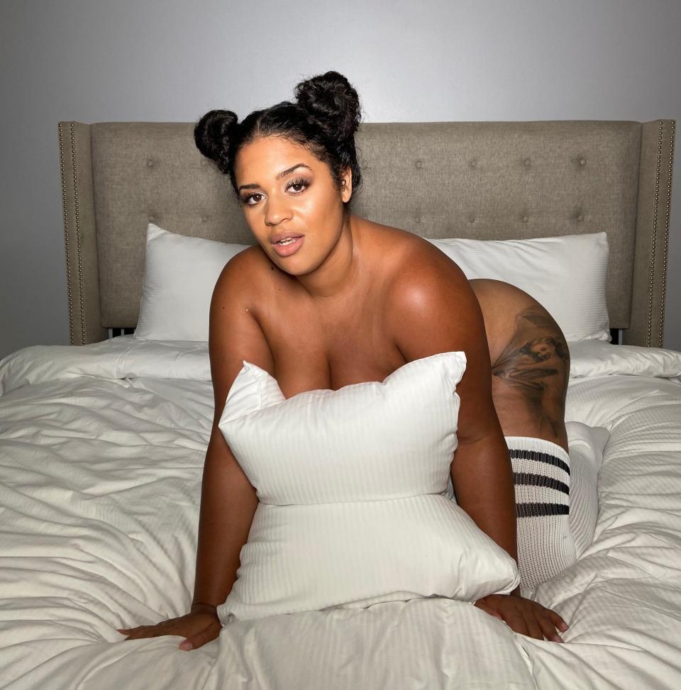 Woman posing on bed with pillow