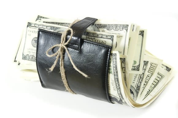 A leather wallet stuffed with hundred-dollar bills