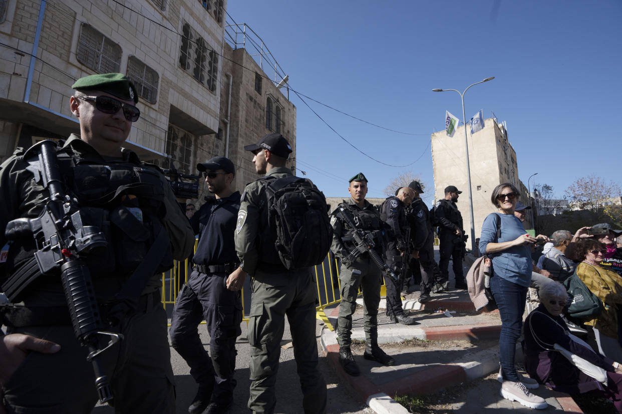 Israeli border police watch activists on a "solidarity tour" of the embattled West Bank city of Hebron, Friday, Dec. 2, 2022. Israeli peace activists toured the occupied West Bank's largest city Friday in a show of solidarity with Palestinians, amid chants of "shame, shame" from ultra-nationalist hecklers.The encounter in the center of Hebron signaled the widening rift among Israelis over the nature of their society and Israel's open-ended military rule over the Palestinians, now in its 56th year. (AP Photo/Maya Alleruzzo)