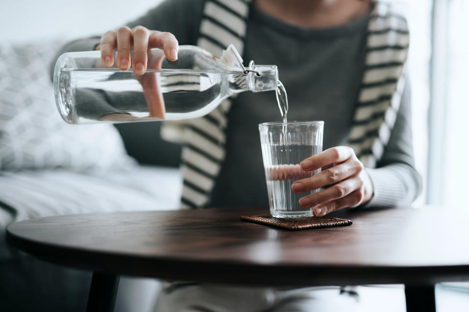 A person pouring themselves a glass of water