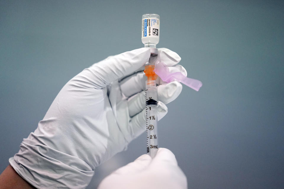 FILE - In this March 26, 2021, file photo, a member of the Philadelphia Fire Department prepares a dose of the Johnson & Johnson COVID-19 vaccine at a vaccination site setup at a Salvation Army location in Philadelphia. With the U.S. pause of the vaccine, authorities are weighing whether to resume the shots the way European regulators decided to -- with warnings of a “very rare” risk. New guidance is expected late Friday, April 23, after a government advisory panel deliberates a link between the shot and a handful of vaccine recipients who developed highly unusual blood clots. (AP Photo/Matt Rourke, File)