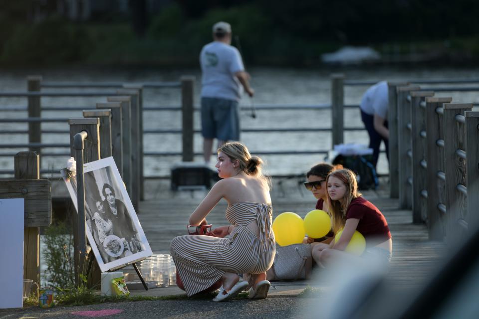 About 300 students and parents gathered at Fisherman's Landing in Holland to hold a candlelight vigil for the three teens who were killed in a car crash in Brimfield, June 26, 2022.