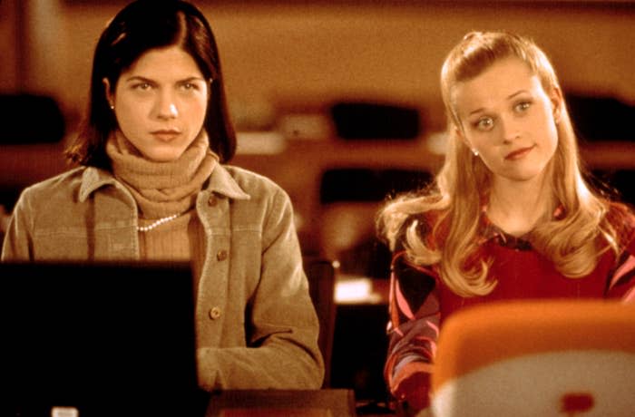 Selma Blair and Reese Witherspoon in a scene from "Legally Blonde," sitting at desks looking ahead