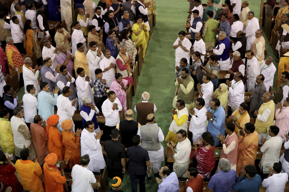 Indian prime Minister Narendra Modi, center, greets newly elected lawmakers at Bharatiya Janata Party (BJP) parliamentary and their alliance meeting in New Delhi, India, Saturday, May 25, 2019. BJP president Amit Shah announced Modi's name as the leader of the National Democratic Alliance in a meeting of the lawmakers in the Central Hall of Parliament in New Delhi, paving the way for Modi's second five-year term as prime minister after a thunderous victory in national elections. On the left, is the huge portrait of India's first prime minister Jawaharlal Nehru. (AP Photo/Manish Swarup)