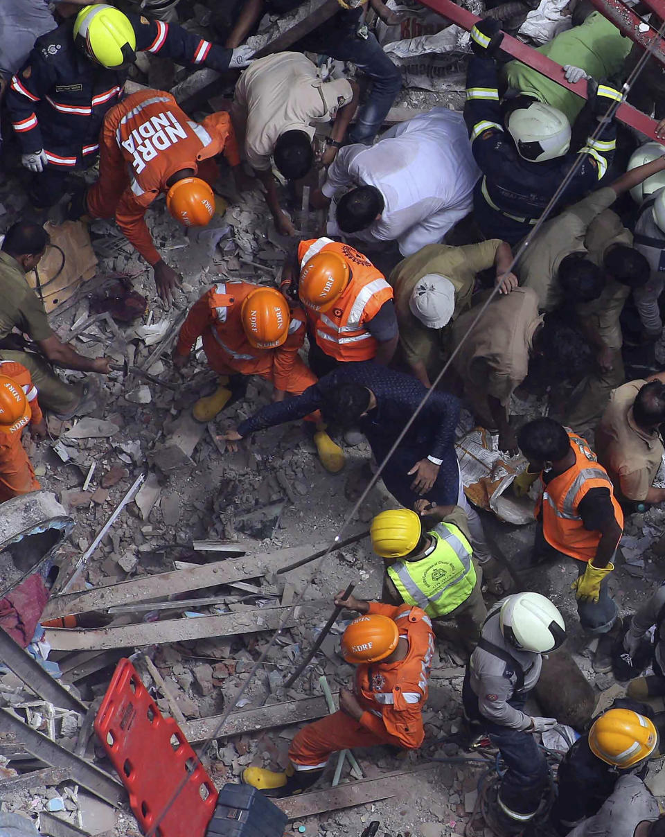 Rescuers work at the site of a building that collapsed in Mumbai, India, Tuesday, July 16, 2019. A four-story residential building collapsed Tuesday in a crowded neighborhood in Mumbai, India's financial and entertainment capital, and several people were feared trapped in the rubble, an official said. (AP Photo/Rajanish Kakade)