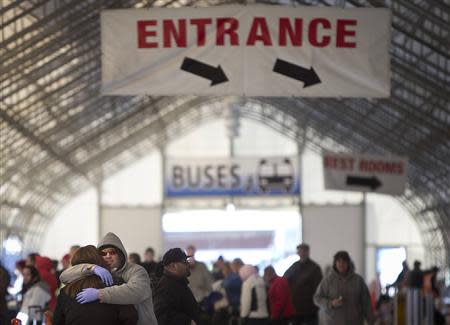 People hug in a departure lounge after Royal Caribbean's cruise ship, Explorer of the Seas arrived back at Bayonne, New Jersey January 29, 2014. REUTERS/Carlo Allegri