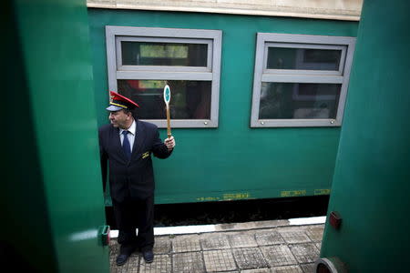 A railway worker controls traffic in front of a train at Kostandovo railway station, Bulgaria April 28, 2015. REUTERS/Stoyan Nenov