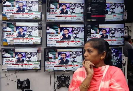 A woman watches a news television debate about opposition leader Rahul Gandhi's hug to Prime Minister Narendra Modi during a no-confidence motion in parliament, at an electronics store in Kolkata, India, July 20, 2018. REUTERS/Rupak De Chowdhuri