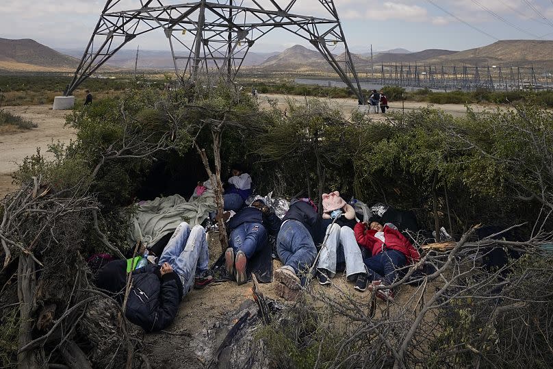 Varios inmigrantes duermen en un campamento improvisado mientras esperan para solicitar asilo, tras cruzar la frontera estadounidense, cerca de Jacumba, en California.