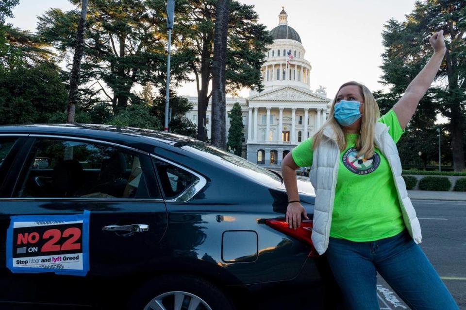 Erica Mighetto, una conductora de Uber y Lyft, se manifiesta en el Capitolio en un mitin de trabajadores de la industria del transporte contra la Propuesta 22, la iniciativa electoral más cara de la historia del estado, antes de su aprobación en 2020. La iniciativa exime a los servicios de transporte y entrega basados en aplicaciones de la Ley de la Asamblea 5, permitiéndoles seguir empleando a conductores como contratistas independientes.