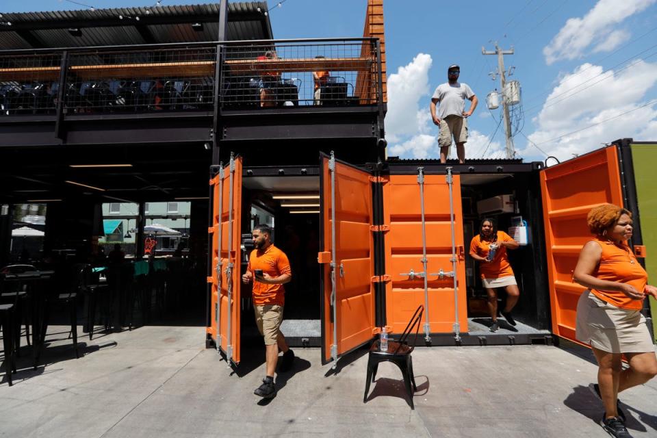 Staffers work on last-minute preparations Wednesday afternoon, May 22, 2024, at the Downtown Fort Myers outdoor venue Bay Street Yard. The establishment will include bars, concert stage, food truck spaces as well as table games among other amenities.