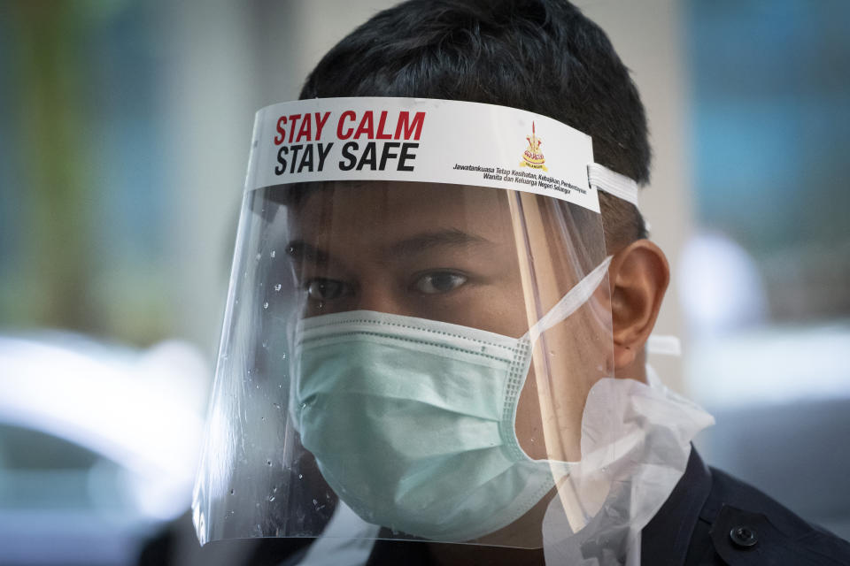 A healthcare staff member looks on as he arranges for residents to collect samples for coronavirus testing at an urban area in Bandar Utama, outskirts of Kuala Lumpur, Malaysia Thursday, Oct. 22, 2020. Malaysia restrict movements in its biggest city Kuala Lumpur, neighboring Selangor state and the administrative capital of Putrajaya from Wednesday in an attempt to curb a sharp rise in coronavirus cases. (AP Photo/Vincent Thian)