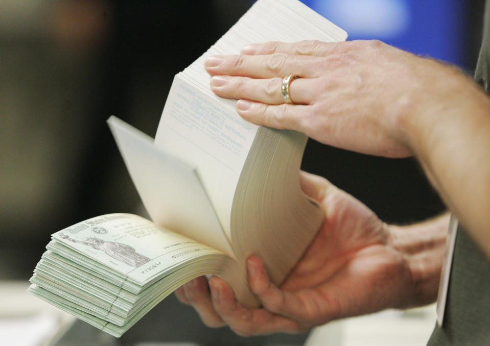 An unidentified printer looks over stimulus checks at the Kansas City Regional Financial Center in Kansas City, Mo., Thursday, May 8, 2008. The first batch of rebate payments started hitting bank accounts last week through direct deposits. Paulson, Vice President Dick Cheney and other Bush administration officialsare visiting government check printing centers around the country on Thursday for events highlighting the fact that millions of rebate checks are in the mail. (AP Photo/Orlin Wagner)