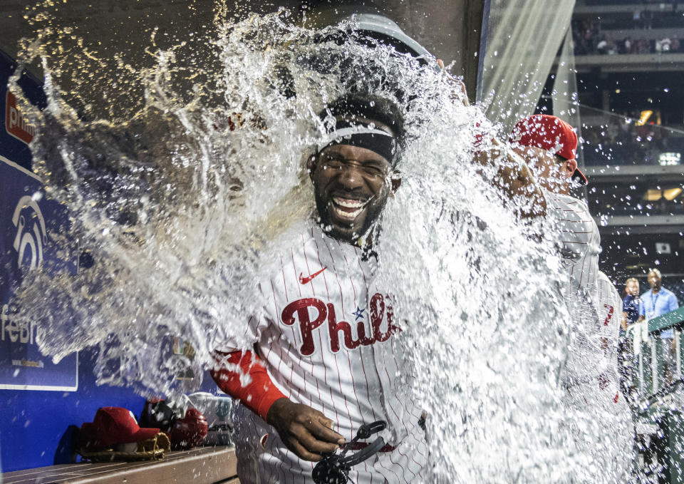 Philadelphia Phillies' Andrew McCutchen is dunked with water by Rhys Hoskins and Archie Bradley after hitting a three-run, walk-off home run in the ninth inning of a baseball game against the Washington Nationals, Monday, July 26, 2021, in Philadelphia. (AP Photo/Laurence Kesterson)