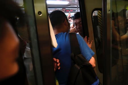 Anti-extradition bill demonstrators block a Mass Transit Railway (MTR) train in Hong Kong