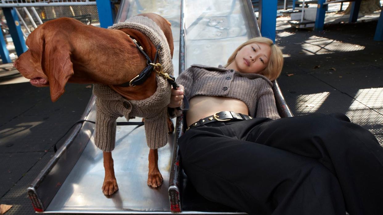 a person lying on a bench with a dog