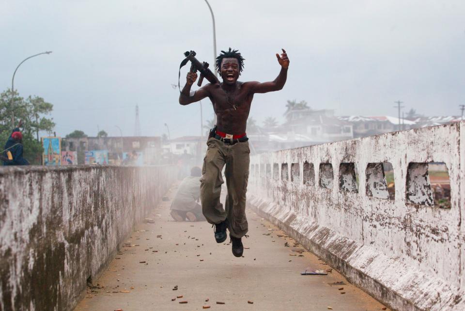 Joseph Duo, a Liberian militia commander loyal to the government, exults after firing a rocket-propelled grenade at rebel forces at a key strategic bridge July 20, 2003 in Monrovia, Liberia. Government forces succeeded in forcing back rebel forces in fierce fighting on the edge of Monrovia's city center.