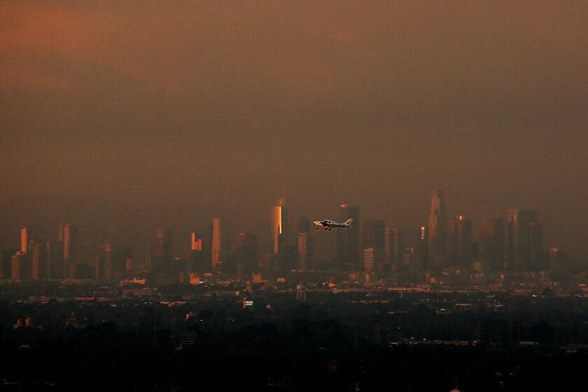 LONG BEACH, CALIF. - DEC. 4, 2023. The Los Angeles skyline, miles in the distance, serves as a backdrop for a small plane taking off from the Long Beach Airport on a recent afternoon. (Luis Sinco / Los Angeles Times)