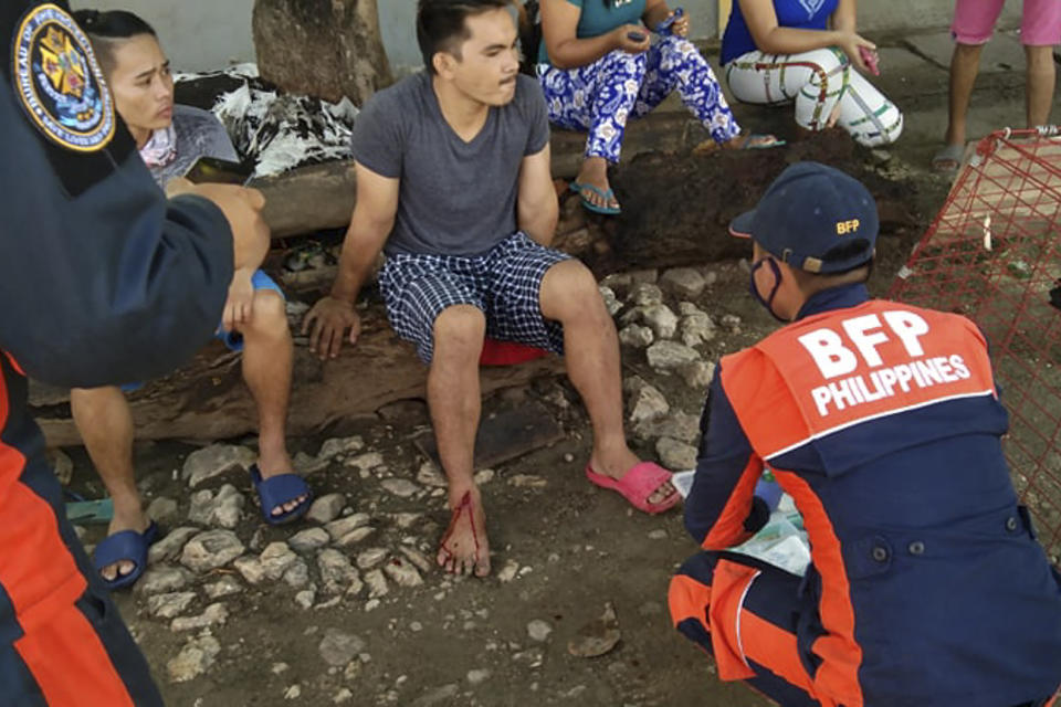 An injured man is treated after a strong earthquake struck in Cataingan, Masbate province, central Philippines on Tuesday Aug. 18, 2020. A powerful and shallow earthquake struck a central Philippine region Tuesday, prompting people to dash out of homes and offices but there were no immediate reports of injuries or major damage. (AP Photo/ Christopher Decamon)