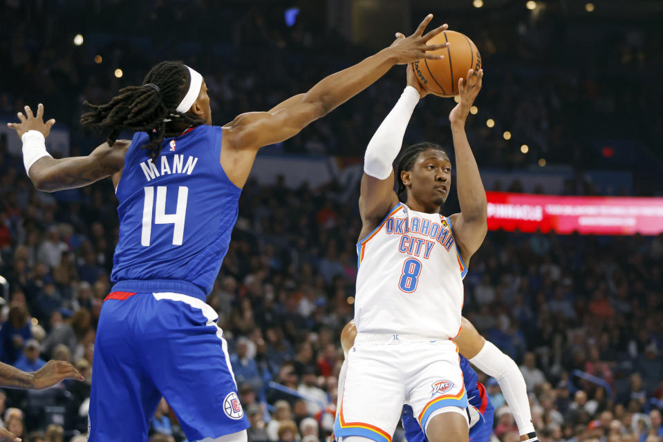 Oklahoma City Thunder forward Jalen Williams (8) prepares to pass the ball away from Los Angeles Clippers guard Terance Mann (14) during the first half of an NBA basketball game Thursday, Dec. 21, 2023, in Oklahoma City. (AP Photo/Nate Billings)